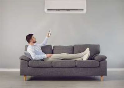 Familie genießt entspannt Wärme zu Hause, blickt auf Laptop mit Ventron Heizungs- und Klimatisierungslösungen.